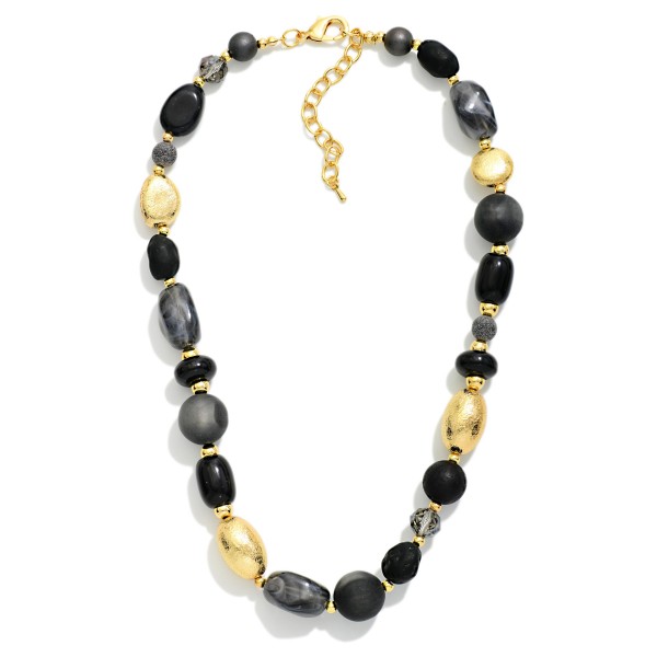 Chunky Mixed Bead Necklace layering glossy and matte beads in varied shapes with textured metal accent beads. The graduated, collar length design makes a bold statement on its own or styled over turtlenecks and button downs. A lobster clasp and extender chain allow an easy, adjustable fit. Earthy, oversized necklaces are a fall favorite that give boutiques an easy, outfit completing upsell.