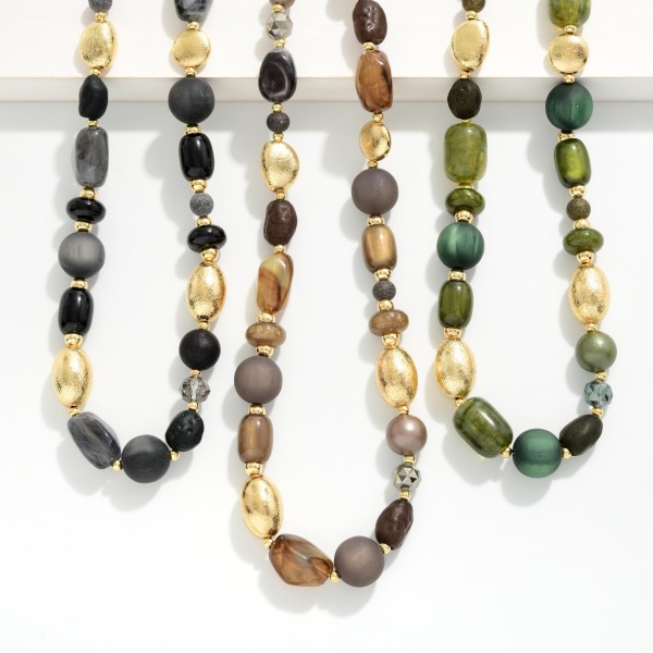Chunky Mixed Bead Necklace layering glossy and matte beads in varied shapes with textured metal accent beads. The graduated, collar length design makes a bold statement on its own or styled over turtlenecks and button downs. A lobster clasp and extender chain allow an easy, adjustable fit. Earthy, oversized necklaces are a fall favorite that give boutiques an easy, outfit completing upsell.