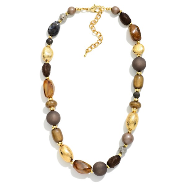Chunky Mixed Bead Necklace layering glossy and matte beads in varied shapes with textured metal accent beads. The graduated, collar length design makes a bold statement on its own or styled over turtlenecks and button downs. A lobster clasp and extender chain allow an easy, adjustable fit. Earthy, oversized necklaces are a fall favorite that give boutiques an easy, outfit completing upsell.