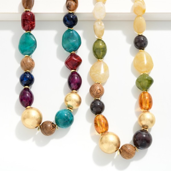Mixed Bead Statement Necklace combining smooth nuggets, faceted glass, and polished metal beads in a graduated design. The varied shapes and textures give it a collected, artisan feel that elevates basic tees and knits. Finished with a lobster clasp and extender chain for an adjustable fit. A rich fall layering piece that boutiques can style with sweaters and jackets for an easy add on sale.