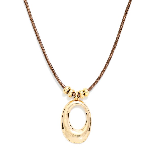 Sculpted Oval Pendant Necklace on a soft cord with sliding metal bead accents above a polished open oval pendant. The cord length makes it easy to wear high on the neck or lower over a sweater. A modern everyday piece for work, weekend outfits, and layering with fine chains. Clean, minimalist styles like this appeal to a wide range of customers and sell steadily all year.