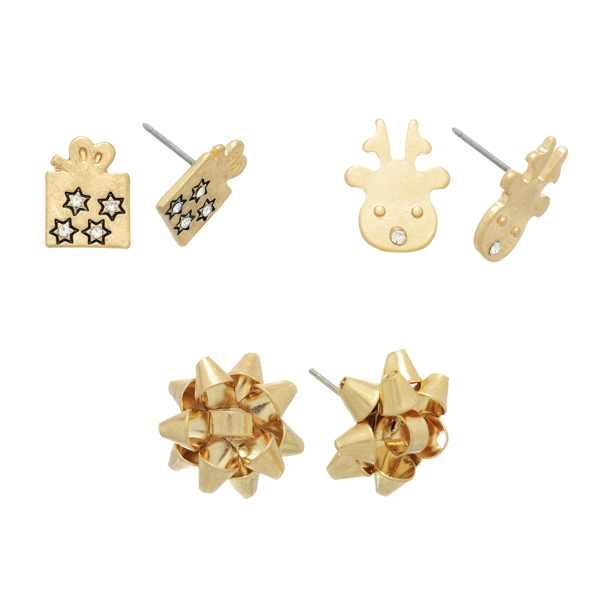 Worn gold tone set of three post earrings featuring a gift, a reindeer, and a gift bow.