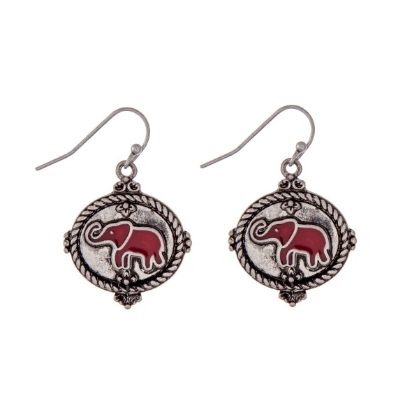 Silver tone fishhook earrings with a crimson epoxy elephant. Approximately 1" in length. 