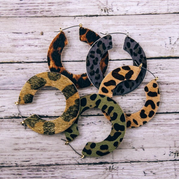 Leopard print cowhide flat pin catch hoop earrings. 

- Approximately 2" in diameter