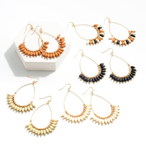 Teardrop earrings with Gray colored ellipsoid wood beads separated by gold circular beads. 

-Approximately 1.5 inch wide 
-Tassel beads approximately 0.5 inches long 