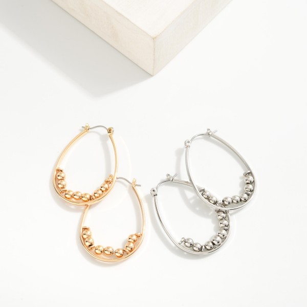 Metal Teardrop Earrings Featuring Beaded Accents
- Approximately 1.25"L
