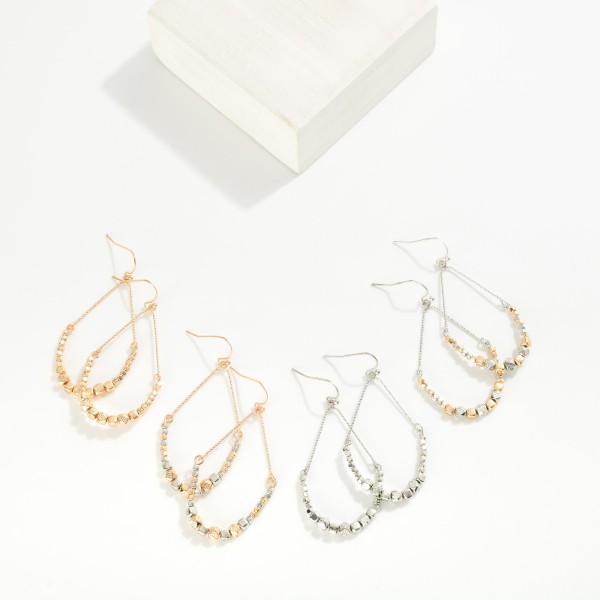 Metal Tone Teardrop Drop Earrings Featuring Geometric Shape Bead Details

- Approximately 2" L