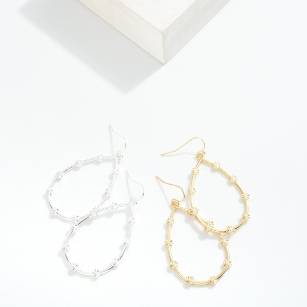 Metal Tone Teardrop Earrings Featuring Starburst Details

- Approximately 2.25" L