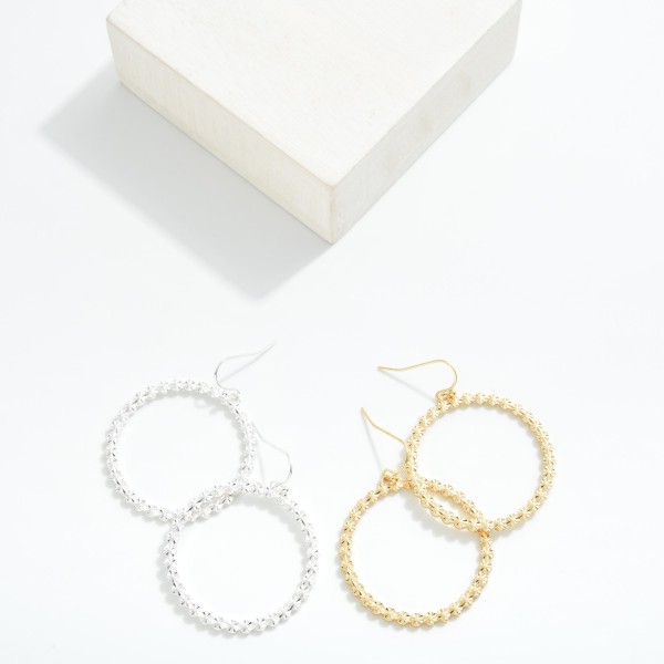 Metal Tone Drop Hoop Earrings Featuring Starburst Detail 