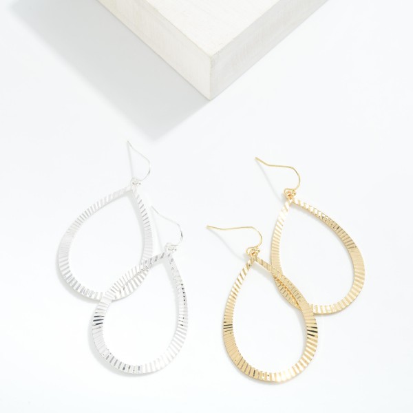 Metal Tone Teardrop Shaped  Drop Earring Featuring Textured Ridged Pattern  

- Approximately 2" L