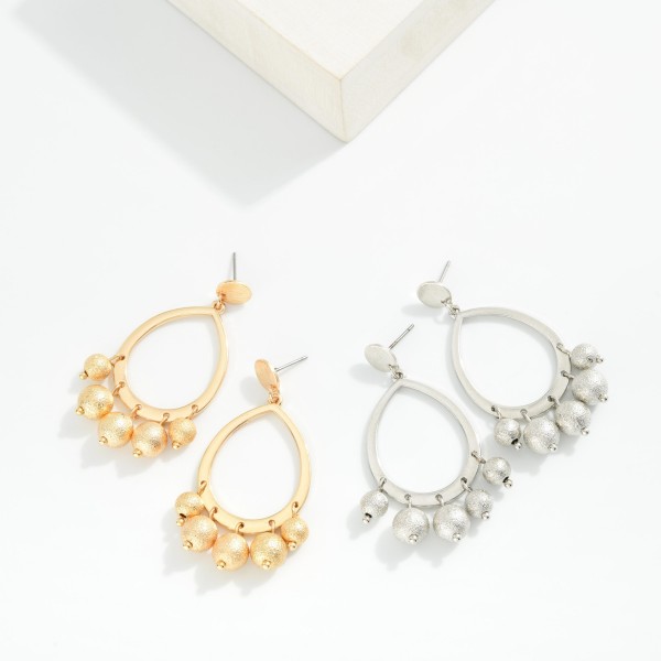 Metal Tone Teardrop Hoop Earring Featuring Textured Metal Ball Bead Dangle Detail

- Approximately 2" L

