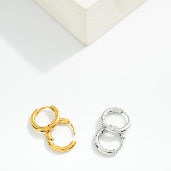 Metal Tone Huggie Hoop Earrings

- Approximately .25" D
- Hypoallergenic 
- Water Resistant 
