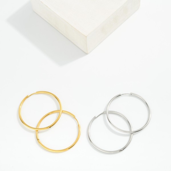 Metal Tone Huggie Hoop Earrings

- Approximately 1.5" D
- Hypoallergenic 
- Water Resistant 
