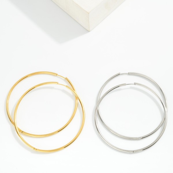 Metal Tone Huggie Hoop Earrings

- Approximately 2.5" D
- Hypoallergenic 
- Water Resistant 
