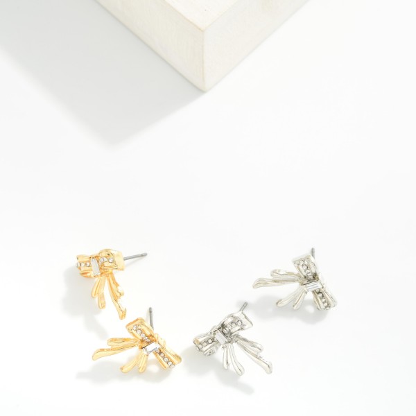 Metal Tone Bow Stud Earrings Featuring Rhinestone Details

- Approximately .75" L