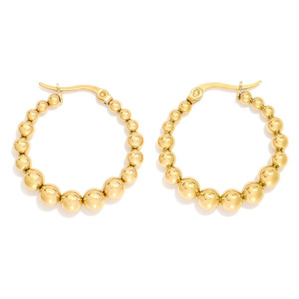 Metal Tone Beaded Huggie Hoop Drop Earring 

- Approximately 1" D 
- Stainless Steel 
- Water Resistant 
- Hypoallergenic