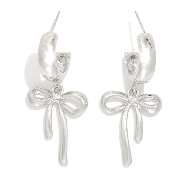  Metal Tone Hoop Earrings Featuring Bow Dangle Detail 

- Gold Dipped 
- Approximately 1.25" L