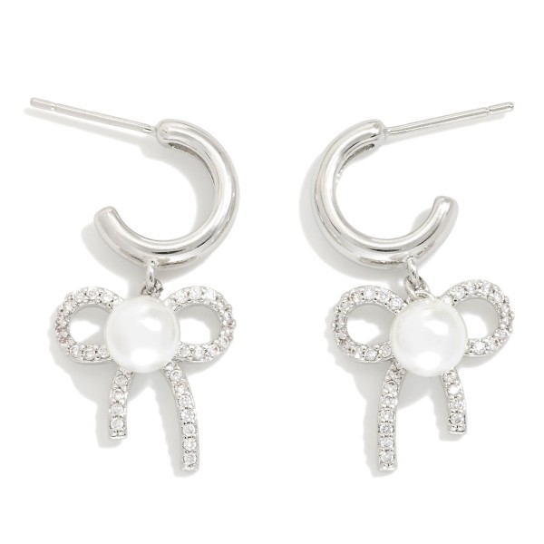  Metal Tone Hoop Earrings Featuring Cubic Zirconia & Pearl Bow Dangle Detail 

- Gold Dipped 
- Approximately 1" L
