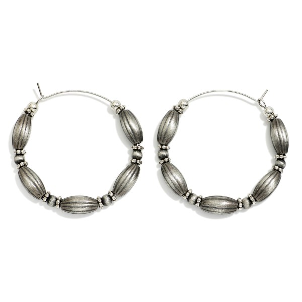 Oval Brushed Metal Beaded Hoop Drop Earring Featuring Stone Beads & Metal Tones 

- Approximately 1.5" D 