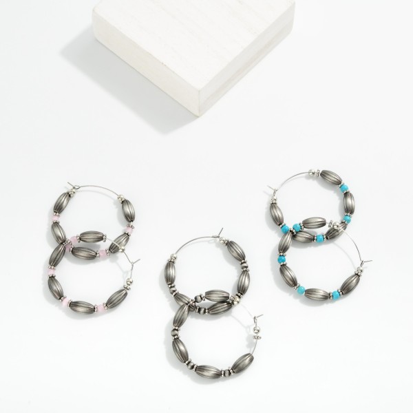 Oval Brushed Metal Beaded Hoop Drop Earring Featuring Stone Beads & Metal Tones 

- Approximately 1.5" D 