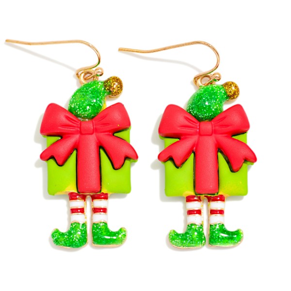 Elf Present Drop Earrings featuring a wrapped gift box with an oversized bow, a glitter elf hat with a tiny bell, and dangling striped legs with curly toed elf shoes. Lightweight construction on fishhook wires makes these playful statement earrings comfortable for hours of holiday fun. Perfect for elf themed parties, classroom celebrations, and ugly sweater contests. Whimsical and full of personality, these are the kind of earrings customers buy for themselves and their friends.