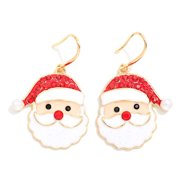 Rhinestone Santa Face Drop Earrings featuring a jolly enamel Santa with a sparkling rhinestone hat, a faux pearl pom, a fluffy textured beard, and a cute button nose on lightweight fishhook wires. Cheerful and easy to wear, they bring instant holiday spirit to sweaters and party outfits. A go to for Christmas parties, classroom celebrations, and photos with Santa. Classic Santa styles are dependable holiday sellers that customers buy every year.