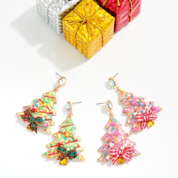 Confetti Christmas Tree Drop Earrings featuring a tree shaped resin charm filled with glitter, star confetti, and tiny pearls, finished with a gingham ribbon bow and a sparkling rhinestone post. The shaker inspired fill catches the light with every move for a playful, sweet holiday look. A favorite for Christmas parties, classroom celebrations, and holiday photos. Bows, glitter, and confetti make these a trend right impulse buy for every age.