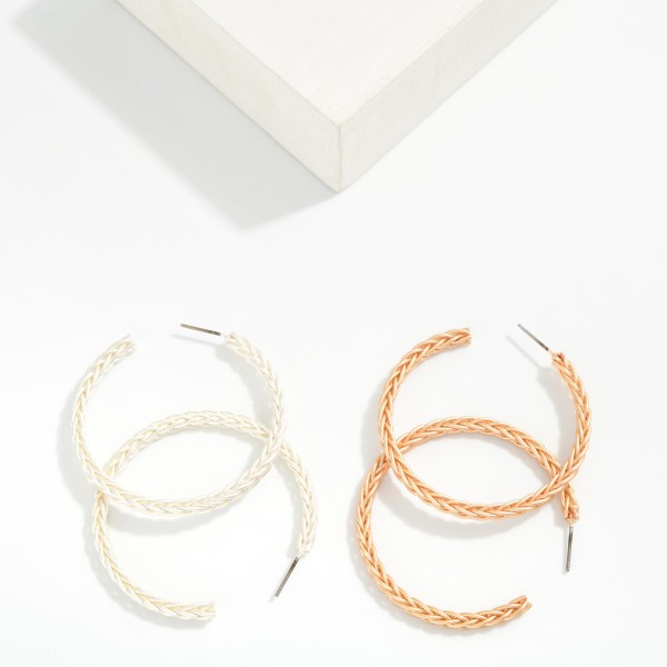 Braided Texture Open Hoop Earrings featuring a slim, open front hoop etched with a woven braid pattern and finished in a soft matte metal tone. The textured surface adds subtle dimension, while the lightweight post design keeps them comfortable all day. An easy everyday hoop that works with casual weekend outfits, workwear, and western looks alike. Versatile, giftable, and priced to move, textured hoops are a staple reorder for boutique jewelry walls.