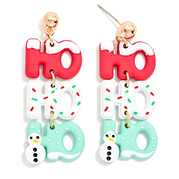 Ho Ho Ho Clay Drop Earrings featuring three stacked HO letters in lightweight clay, decorated with snowy drips, candy sprinkles, and a tiny snowman, hanging from a polished ball post. The tiered design moves with every step and reads clearly from across the room. Made for ugly sweater parties, classroom celebrations, and Santa photos. Playful word earrings are a holiday crowd favorite and an easy, cheerful impulse buy.