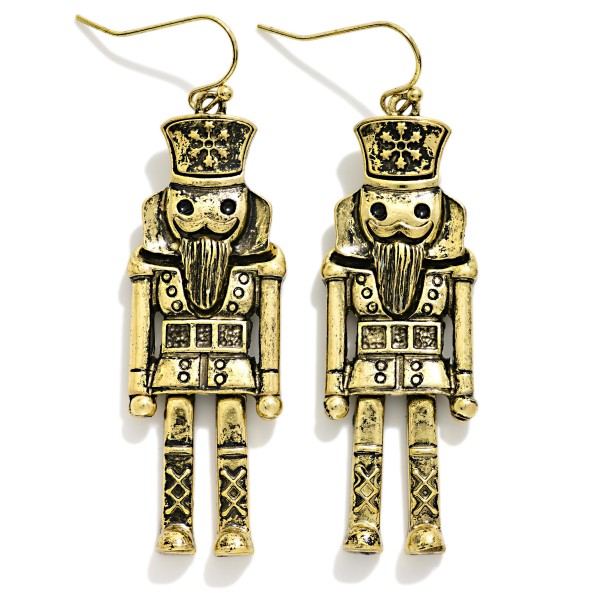 Antiqued Metal Nutcracker Drop Earrings featuring a detailed toy soldier nutcracker with a tall crown hat, carved beard, button coat, and lattice boots, all in a burnished, vintage inspired metal finish. The tall, slender shape hangs gracefully from lightweight fishhook wires. A favorite for Nutcracker ballet season, dance teachers, collectors, and holiday parties. Classic and timeless, nutcracker jewelry sells every Christmas and makes an easy gift.