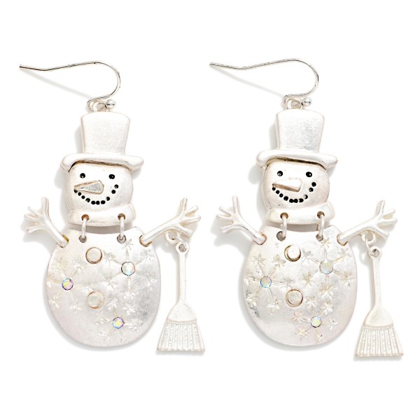 Vintage Metal Snowman Drop Earrings featuring a jolly snowman in a top hat with stick arms, a tiny broom, and etched snowflake details, all in a worn, burnished metal finish. Lightweight fishhook wires keep them comfortable for all day wear. Perfect for winter festivals, classroom parties, and holiday gift exchanges. Whimsical, rustic, and priced right, these are an easy seasonal add on that sells from November through January.