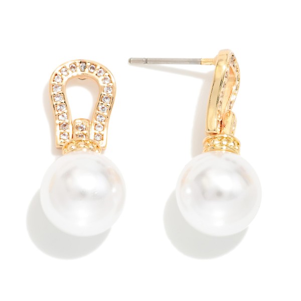 Pave Horseshoe Pearl Drop Earrings featuring a sparkling cubic zirconia horseshoe post with a large, lustrous faux pearl suspended below. The equestrian inspired top adds a touch of western charm, while the oversized pearl keeps the look polished and elegant. A stunning choice for weddings, rodeo galas, holiday parties, and special occasions. Pearl drops with a western twist stand out in the case and give boutiques a dressy option that sells beyond the ranch crowd.