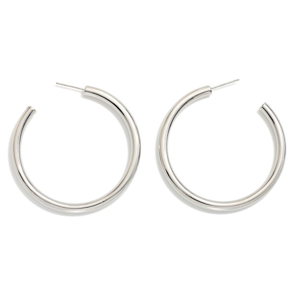 Polished Open Tube Hoop Earrings featuring a smooth, rounded hoop with an open front and a simple post back for an effortless, modern look. The medium size is big enough to make an impression yet light enough to wear from morning to night. An everyday staple that layers easily with studs and huggies and makes a simple, reliable gift. Clean, classic hoops are perennial bestsellers that keep boutique jewelry walls moving.