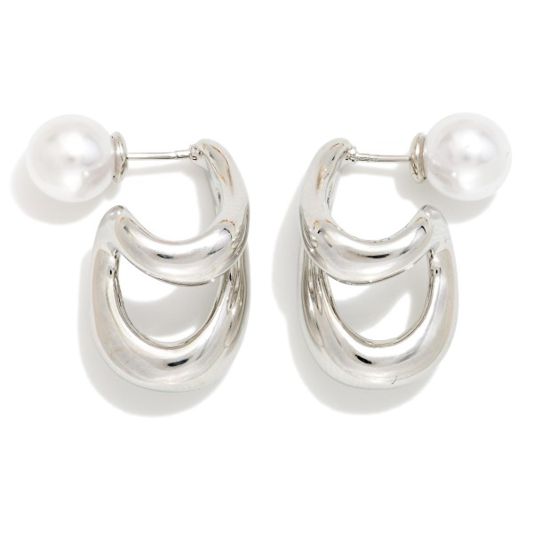 Double Loop Pearl Back Earrings featuring two sculpted, high polish loops that drape below the lobe, finished with a faux pearl ball backing that peeks out behind the ear. The front and back design gives a modern, editorial look from every angle while staying light enough for all day wear. A standout pick for date nights, holiday parties, and fashion forward customers. Statement metals with a pearl twist are trending hard and make a strong impulse sell.