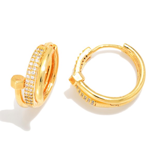 Pave Nail Huggie Hoop Earrings featuring a sleek wraparound nail design with a polished hex head and a row of sparkling cubic zirconia stones along the front. The hinged huggie closure snaps securely and sits close to the ear for a modern, high end look. A trend right gift for birthdays, graduations, and anyone who loves elevated everyday jewelry. Luxe inspired huggies are a strong seller at an accessible price point.