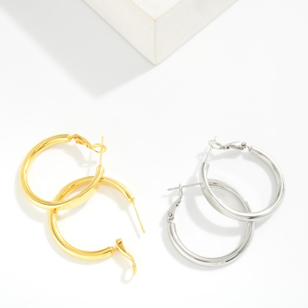 Metal Tone Tube Hoop Earrings Featuring Pressed Metal Detail 

- Approximately 1" D