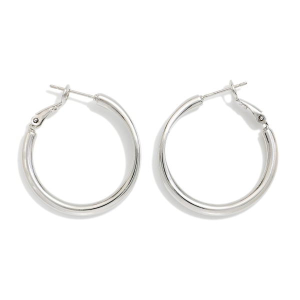Metal Tone Tube Hoop Earrings Featuring Pressed Metal Detail 

- Approximately 1" D