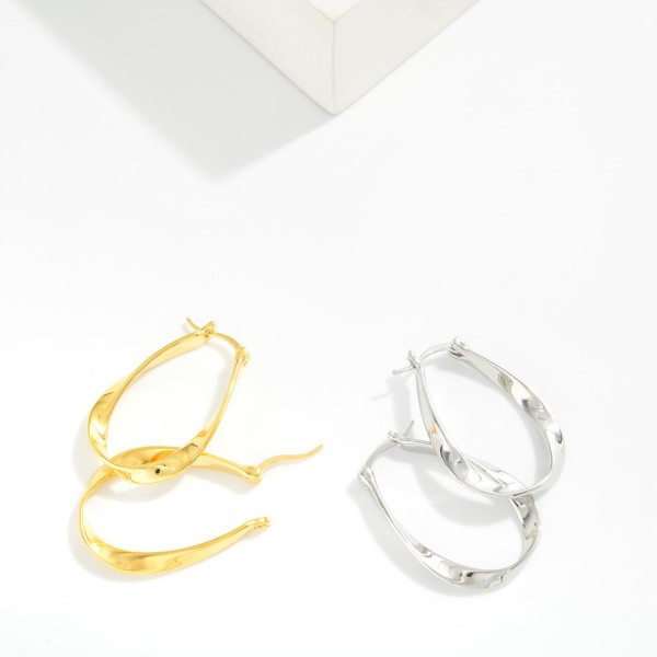 Metal Tone Twisted Flat Oval Hoop Earrings 

- Gold Dipped 
- Approximately 1.25" L X .75" D