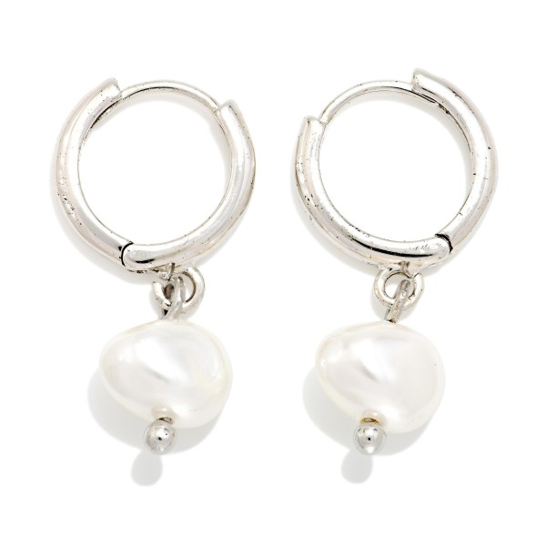 Baroque Pearl Huggie Drop Earrings featuring an organic shaped faux pearl dangling from a polished huggie hoop with a secure hinged closure. The irregular pearl shape gives a modern, artisan feel, while the snug huggie keeps them comfortable from morning meetings to evening plans. A versatile gift for brides, bridesmaids, and anyone who loves classic polish with a twist. Pearl huggies are a top trend, making these an easy, fast turning add on.
