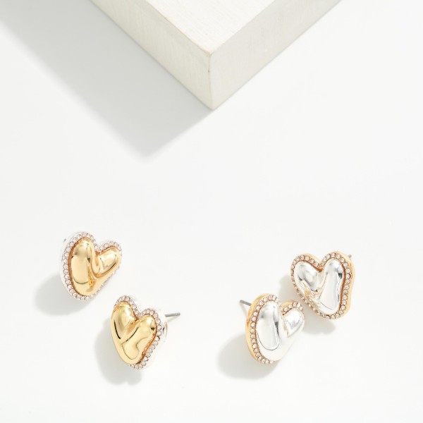 Rhinestone Halo Heart Stud Earrings with a puffy hammered metal heart framed by a sparkling crystal border. The organic heart shape and pave edge make them feel special, while post backs keep them secure for all day wear. A sweet pick for Valentine's Day, Galentine's gifts, birthdays and everyday sparkle. Heart studs sell year round and make an easy add on at the register.
