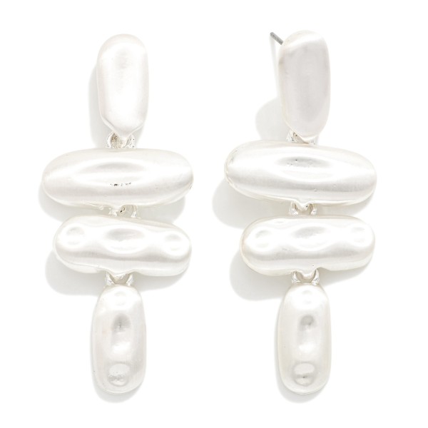 Molten Metal Drop Earrings stacking four organic oval shapes with a hammered, liquid look in a soft matte finish. Bold but lightweight, they hang from post tops for a sculptural statement that still feels easy to wear. Great for holiday parties, art walks, date nights and dressing up a simple sweater. Sculptural metal styles are trending, and this pair delivers the look at a boutique friendly price.