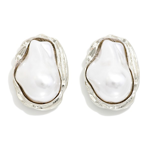 Baroque Pearl Stud Earrings featuring an organic shaped faux pearl framed in a sculpted metal bezel. The irregular pearl gives each pair a modern, artisan look while keeping the classic appeal of pearls. Post backs for secure, comfortable wear. An elegant everyday stud that also works for weddings, showers, and gifting, and pairs well with the coordinating baroque pearl necklace.