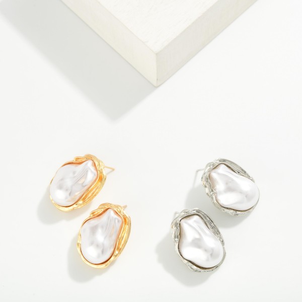 Baroque Pearl Stud Earrings featuring an organic shaped faux pearl framed in a sculpted metal bezel. The irregular pearl gives each pair a modern, artisan look while keeping the classic appeal of pearls. Post backs for secure, comfortable wear. An elegant everyday stud that also works for weddings, showers, and gifting, and pairs well with the coordinating baroque pearl necklace.