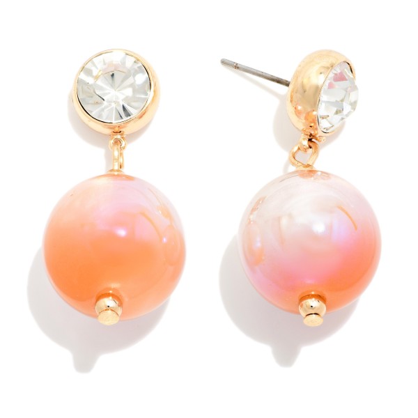 Crystal Stud Pearl Drop Earrings featuring a round bezel set crystal stud with an oversized lustrous pearl bead suspended below. The pairing of sparkle and soft sheen feels polished and elegant without being fussy. Post backs keep them secure and comfortable. Perfect for holiday parties, weddings, and date nights, and a strong gift option offered in several pearl finishes.