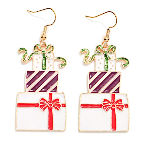 Stacked Present Drop Earrings featuring a tower of glossy enamel gift boxes tied with ribbon bows, finished with a touch of glitter on the top package. Lightweight fishhook wires make them easy to wear all day, from the office party to the family gift exchange. A playful, giftable style that brings instant holiday cheer to sweaters and festive tees. Bright and whimsical, these are a fun impulse add on that sells all season.