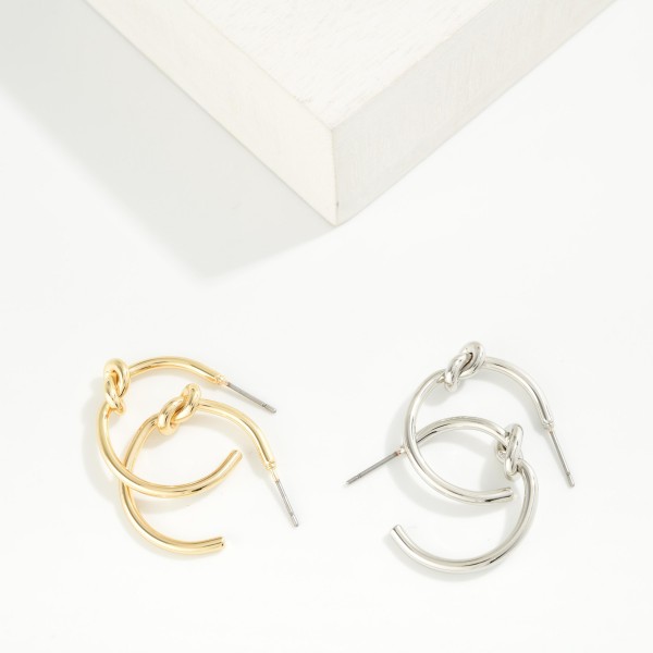 Knotted Open Hoop Earrings featuring a polished tube hoop tied with a sculptural knot at the side. The knot detail adds a modern twist to a timeless hoop shape, making these easy to wear every day. Post backs for comfortable, secure wear. A versatile style that sells across ages and pairs well with the coordinating knot stud earrings and bangles.