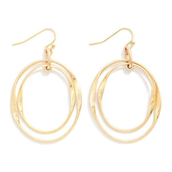 Layered Oval Drop Earrings featuring two overlapping open ovals, one polished and one hammered, hanging from simple fishhook wires. The offset layers create a sculptural, modern look with subtle movement. Light and comfortable for all day wear. A versatile metal earring that pairs with everything in a customer's closet and makes a great entry price point for your earring wall.