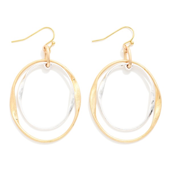 Layered Oval Drop Earrings featuring two overlapping open ovals, one polished and one hammered, hanging from simple fishhook wires. The offset layers create a sculptural, modern look with subtle movement. Light and comfortable for all day wear. A versatile metal earring that pairs with everything in a customer's closet and makes a great entry price point for your earring wall.