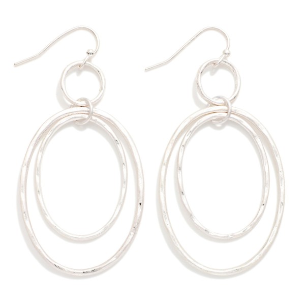 Hammered Double Oval Drop Earrings with layered open ovals, one smooth and one softly hammered, suspended from a small ring on fishhook wires. The airy design adds movement and texture without weight. Comfortable for all day wear. A modern metal earring that pairs effortlessly with casual and dressy outfits and works as an easy everyday bestseller.