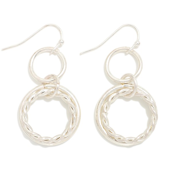 Twisted Rope Double Hoop Drop Earrings featuring a smooth open ring paired with a twisted rope hoop, suspended from a small circle link on fishhook wires. The layered texture adds dimension and movement without extra weight. Easy to wear from day to night. Offered in mixed and single metal finishes, they make a versatile everyday style that sells across a wide range of customers.